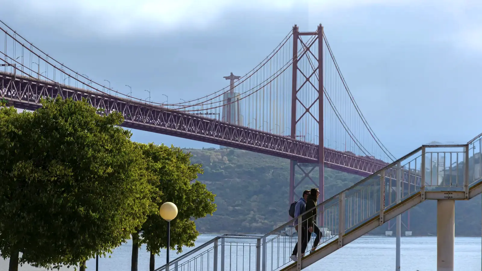 Man On Walkway Viewing Lisbon Bridge